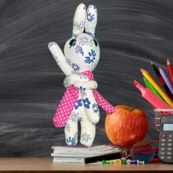 a stuffed animal standing on top of books and a calculator